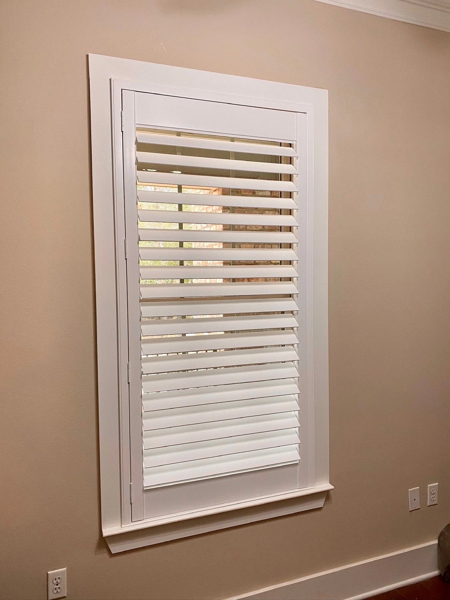 Close-up of a window with white louvered slats
