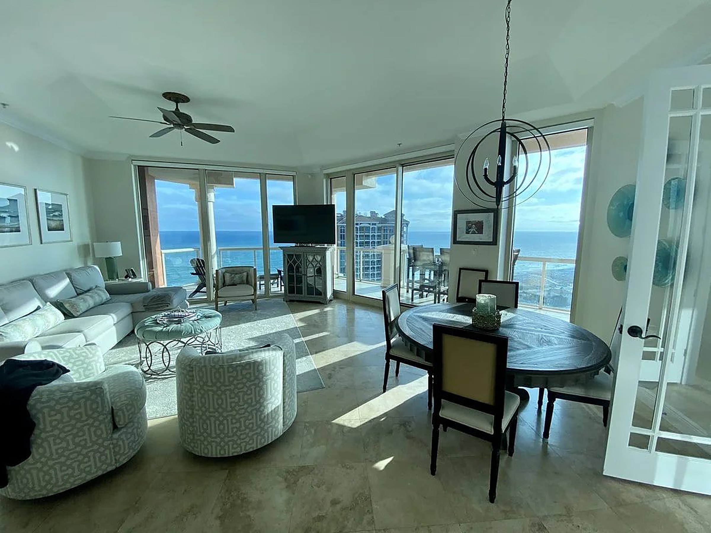 Gulf-view living room with custom shades on floor-to-ceiling windows