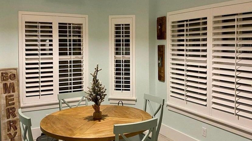 Dining room with green walls and plantation shutters