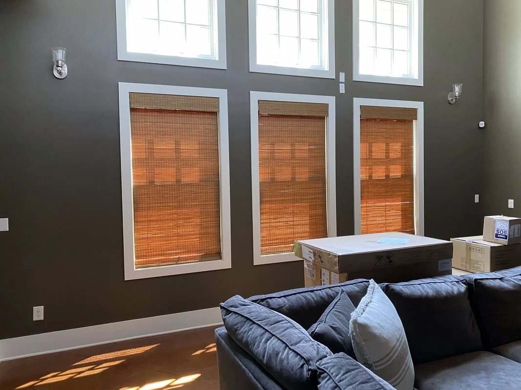Living room with bamboo woven grass shades across three windows