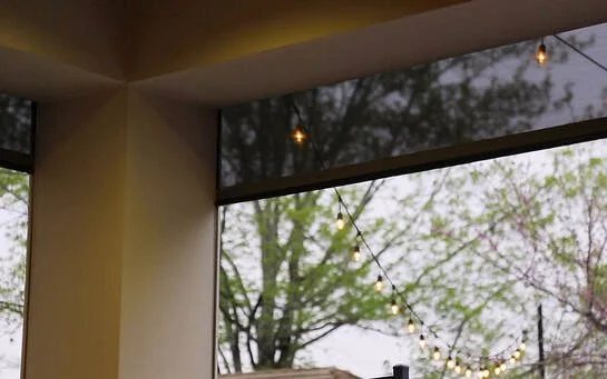 Patio with an exterior motorized shade and string lights